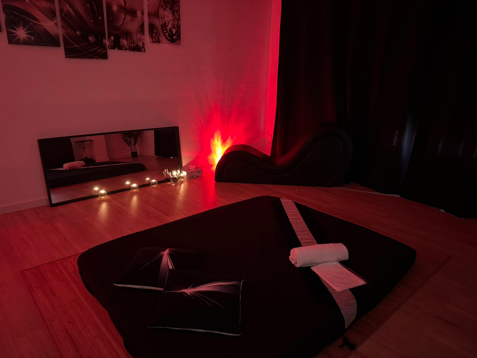 Sala de masaje con espejo y silla tántrica